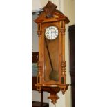 A 19TH CENTURY AUSTRIAN WALNUT REGULATOR WALL CLOCK Having a carved pediment and column supports,