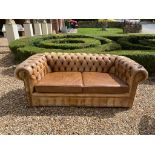 A VICTORIAN DESIGN TAN LEATHER BUTTON BACK CHESTERFIELD SETTEE With loose cushions early/mid 20th