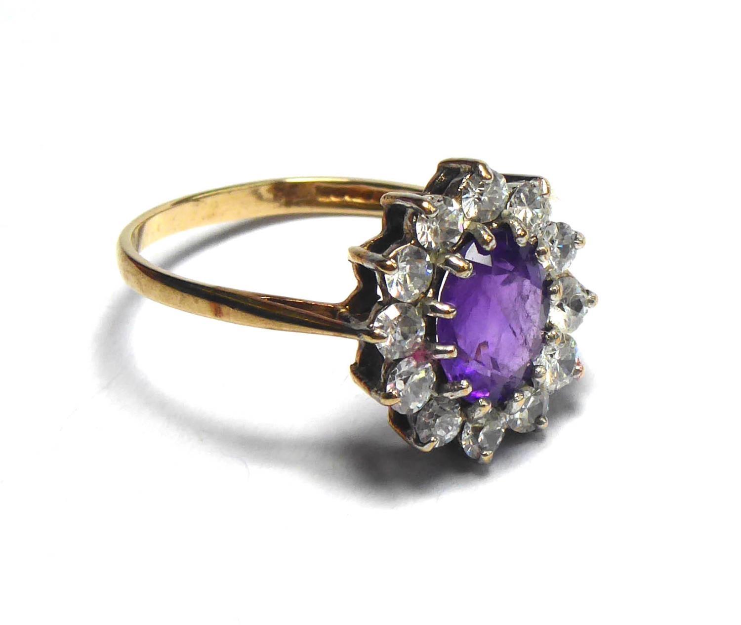 A 9CT GOLD AMETHYST AND PASTE RING The oval cut amethyst edged in paste stones. (size O/P) - Image 2 of 2