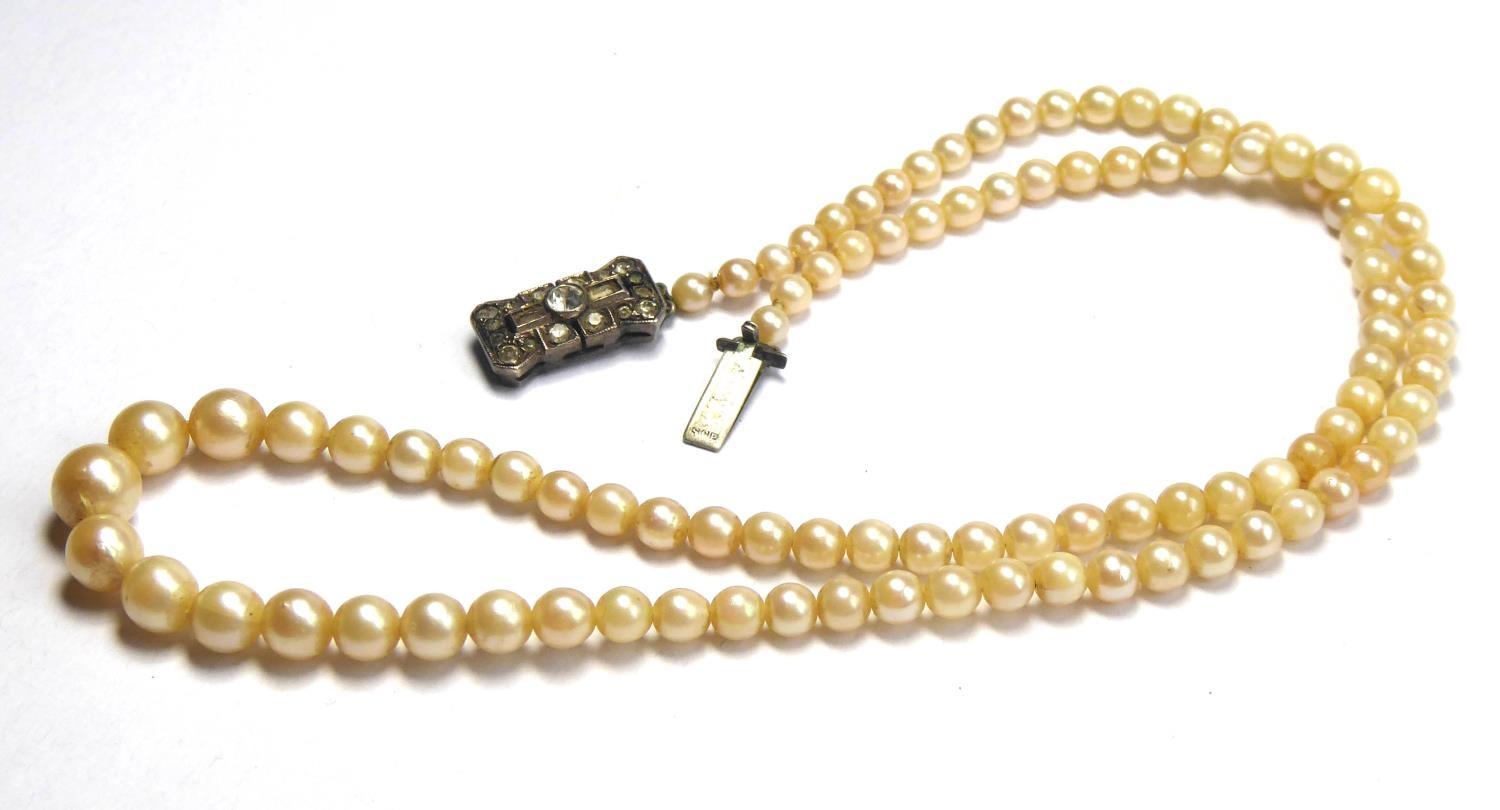 AN EARLY 20TH CENTURY PEARL NECKLACE Having a single strand of pearls on a white metal and paste set