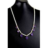 A VINTAGE 9CT GOLD, AMETHYST AND SEED PEARL NECKLACE The single strand of seed pearls with graduated