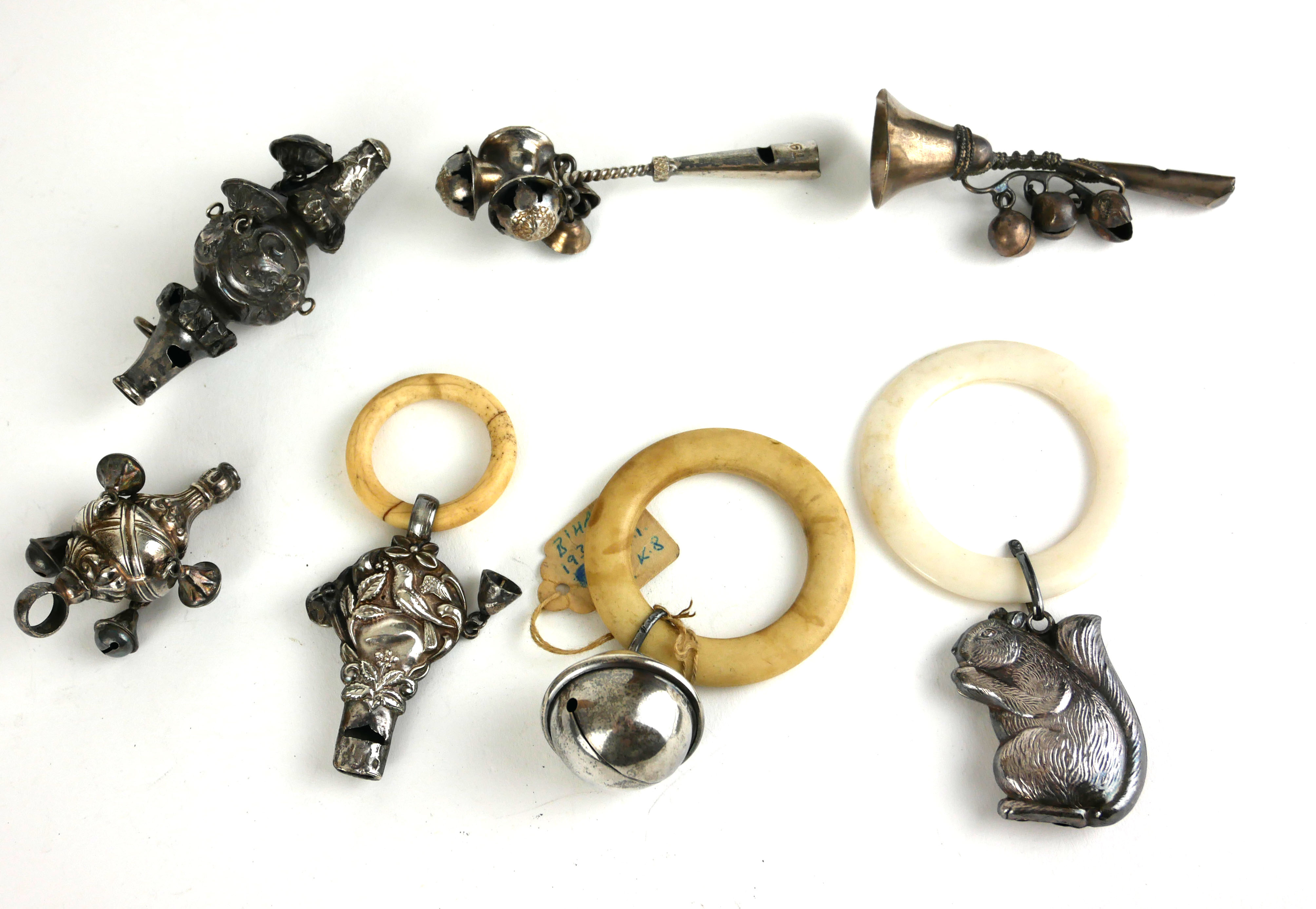 A COLLECTION OF THREE EDWARDIAN WHITE METAL AND IVORY TEETHING RINGS Comprising a squirrel, a