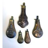 FIVE 19TH CENTURY BRASS AND COPPER POWDER FLASKS. (largest 21cm)