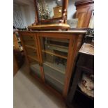 A LATE VICTORIAN FLOOR STANDING OAK BOOKCASE With two glazed doors enclosing adjustable shelves,