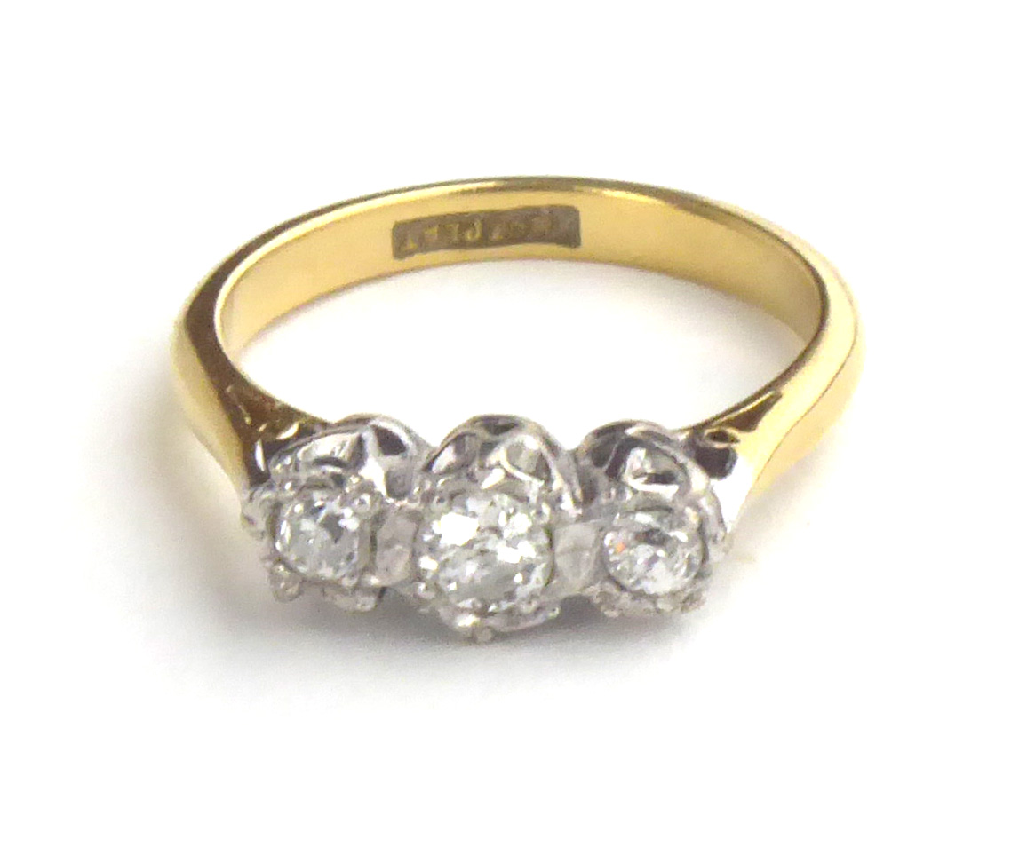 AN EARLY 20TH CENTURY 18CT GOLD AND DIAMOND THREE STONE RING Having a row of graduating stones in