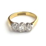 AN EARLY 20TH CENTURY 18CT GOLD AND DIAMOND THREE STONE RING Having a row of graduating stones in