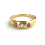 AN EARLY 20TH CENTURY 18CT GOLD, DIAMOND AND RUBY RING Having a single round cut diamond flanked