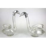 A PAIR OF CONTINENTAL FIGURAL WINE CARAFES FORMED AS SWANS With white metal heads on blown glass