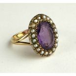 A LATE 19TH/EARLY 20TH CENTURY AMETHYST AND SEED PEARL RING Having an oval cut stone edged with seed