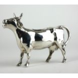 A CONTINENTAL SILVER COW CREAMER Standing pose and having a hinged aperture to back, marked .830