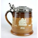 A LARGE NORWEGIAN WHITE METAL AND STONEWARE TANKARD Having horse finial to handle, circular