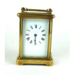 AN EARLY 20TH CENTURY GILT BRASS CARRIAGE CLOCK Having a carry handle with four bevelled glass