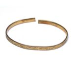 AN EARLY 20TH CENTURY GOLD PLATED SLAVE BANGLE Fine engraved decoration marked 'Metal Core'.
