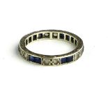 A VINTAGE WHITE METAL SAPPHIRE AND PASTE ETERNITY RING Having square cut stones interspersed with