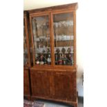 A REGENCY STYLE YEW DISPLAY CABINET With dentil cornice above two glazed doors and cupboards. (113cm