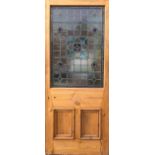A VICTORIAN WAX PINE EXTERIOR DOOR WITH STAINED GLASS PANEL, CIRCA 1880. (83cm x 200cm)