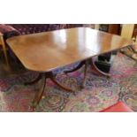 A REGENCY PERIOD MAHOGANY EXTENDING DINING TABLE With one extra leaf, raised on twin pillars four