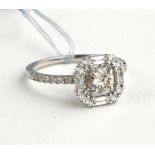 AN ART DECO DESIGN 18CT WHITE GOLD HALO SET DIAMOND RING (SIZE L/M). (total diamond weight 1.7ct)