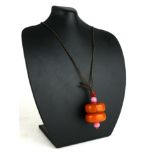 A LARGE AMBER BEAD PENDANT Two circular beads with pink glass spacers. (each bead approx 3.5cm x 1.