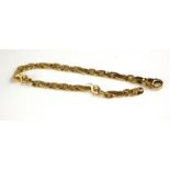 A 14CT GOLD CURB LINK BRACELET Having a pierced half twist design. (approx 20cm)