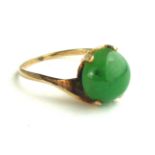 A VINTAGE YELLOW METAL AND CANADIAN JADE RING Having a single cabochon cut stone on a half twist