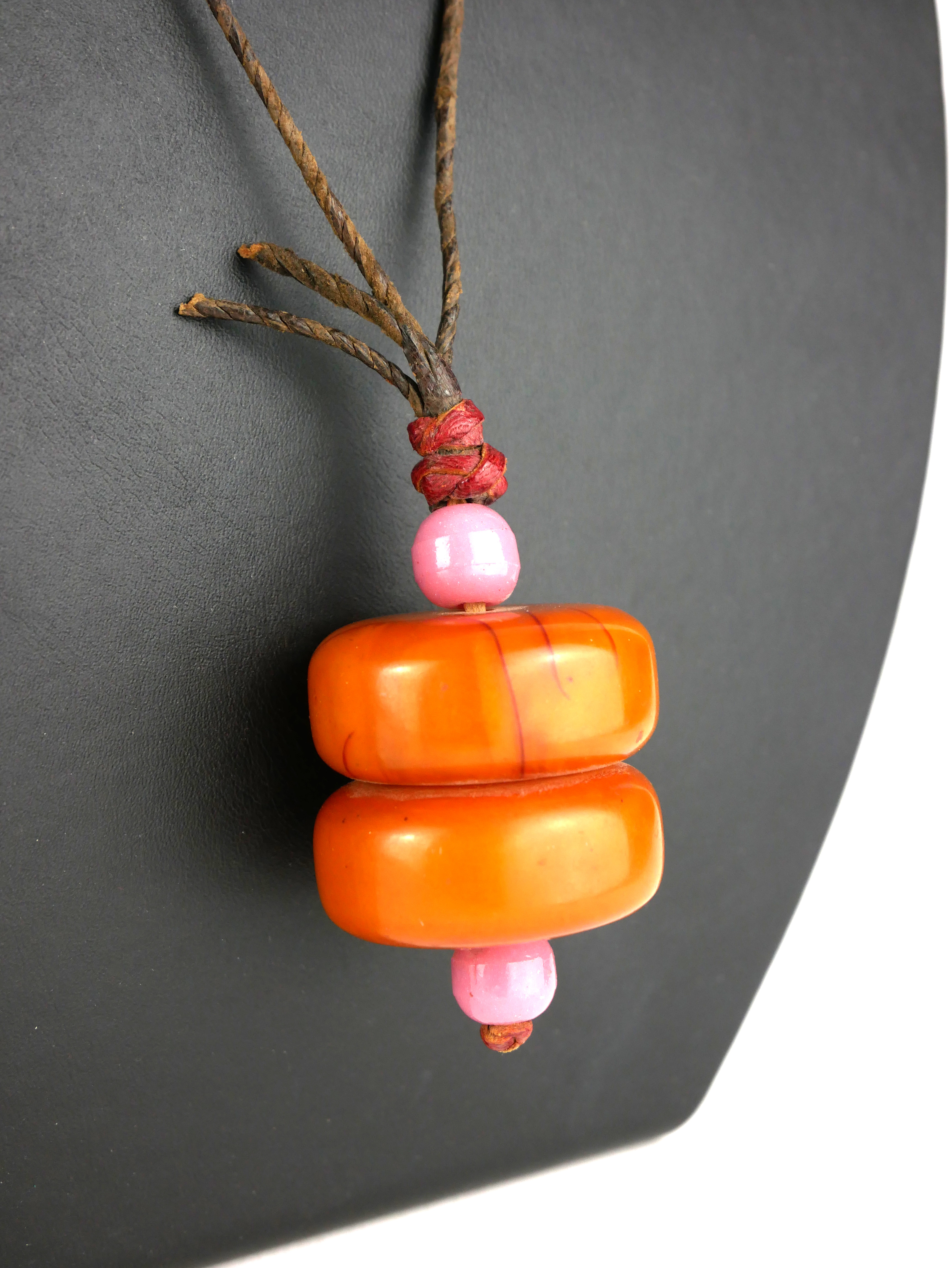A LARGE AMBER BEAD PENDANT Two circular beads with pink glass spacers. (each bead approx 3.5cm x 1. - Image 2 of 2