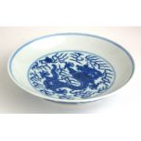 A CHINESE BLUE AND WHITE PORCELAIN SHALLOW DISH Hand painted with a five toe dragon chasing a