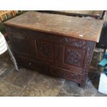 AN ANTIQUE OAK MULE CHEST Heavily carved with florets and foliage, centred with a saintly figure