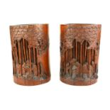 A PAIR OF CHINESE BAMBOO BRUSH POTS Hand carved figures in a wooded landscape. (approx 18cm)