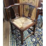 AN 18TH CENTURY YEW WOOD CORNER CHAIR With pierced vase splats and turn rails, rush seat and