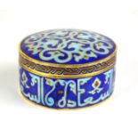 A GILT BRASS AND CHAMPLEVE ENAMEL ISLAMIC DESIGN TRINKET BOX , circular form with scrolled design on