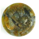 A CHINESE JADE CIRCULAR DESK SEAL Carved with a dragon between two sea creatures, bearing incised
