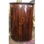 A GEORGIAN MAHOGANY AND SATINWOOD INLAID BOW FRONTED WALL HANGING CORNER CABINET with two doors