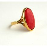 A VINTAGE 18CT GOLD AND CORAL RING Having a cabochon cut oval cut stone. (approx 1.7cm x 1cm)