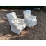 A PAIR OF EARLY 20TH CENTURY EASY ARMCHAIRS With scroll arms and raised on turned mahogany legs,