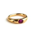 AN 18CT GOLD, RUBY AND DIAMOND RING The single oval cut ruby flanked by diamonds in a rubover