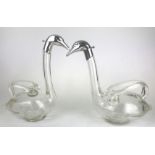 A PAIR OF CONTINENTAL FIGURAL WINE CARAFES FORMED AS SWANS With white metal heads on blown glass