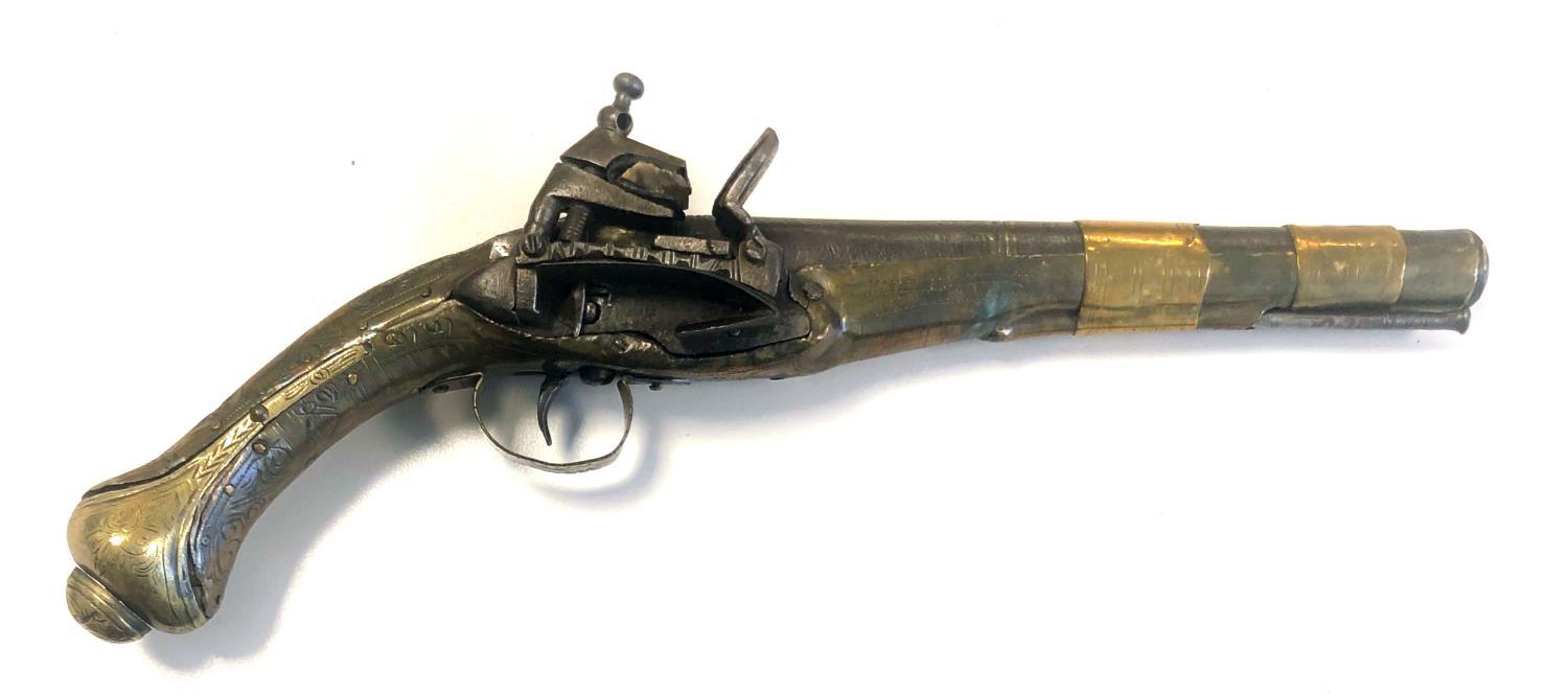 AN 18TH/19TH CENTURY EUROPEAN FLINTLOCK PISTOL With brass bound steel barrel and engraved brass clad