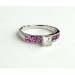 A PLATINUM RING SET WITH CENTRAL PRINCESS CUT DIAMOND ON PINK SAPPHIRE SHOULDERS (SIZE P).