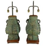 A PAIR OF CHINESE BRONZE ARCHAIC DESIGN VASES MOUNTED AS LAMPS On plinth wood base, double socket
