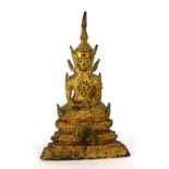 A THAI GILT BRONZE BUDDHA Seated pose with elaborate headdress, on a three tier base. (approx 13cm)