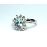 AN 18CT WHITE GOLD, AQUAMARINE AND DIAMOND RING The central oval cut aquamarine edged with