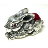 A STERLING SILVER NOVELTY 'RABBIT' PIN CUSHION Recumbent pose, with red velvet cushion. (approx