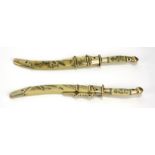 A PAIR OF EARLY 20TH CENTURY JAPANESE MINIATURE SAMURAI DAGGERS/LETTER OPENERS Having white metal
