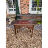 AN EDWARDIAN MAHOGANY WRITING TABLE With two old leather top and drop leaves above arrangement of