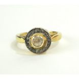 A CONTINENTAL SILVER GILT AND DIAMOND RING Having a central rough cut diamond edged with diamond