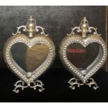 A PAIR OF WHITE METAL PIERCED FRETWORK HEART FORM LANTERN LIGHTS On over scroll organic feet. (53cm)