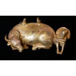 A CHINESE GILT BRONZE FIGURAL GROUP, A RECUMBENT COW With seated bow and a pair of birds, bearing
