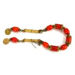 A PERSIAN VINTAGE YELLOW METAL AND AMBER BRACELET The arrangement of oval and cylindrical amber