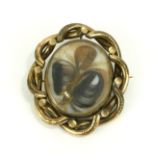 A LARGE VICTORIAN PINCHBECK SWIVEL MOURNING BROOCH Having an oval compartment set with platted hair,